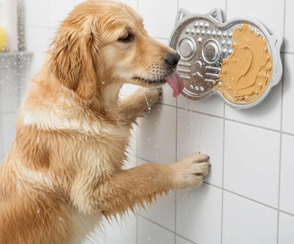 A golden retriever licking a Vivifying stainless steel lick mat stuck to a tiled bathroom wall